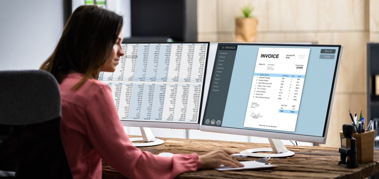 Profesional revisando facturas y reportes tributarios en pantalla